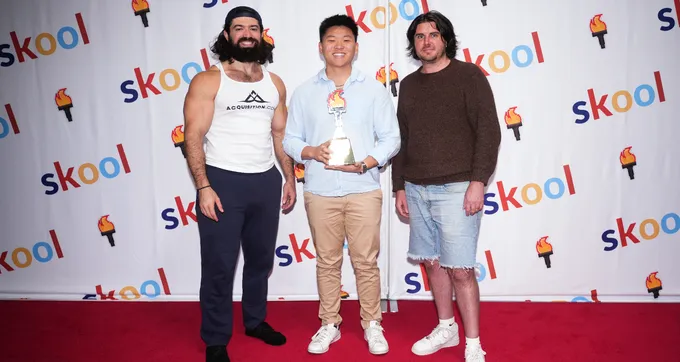Nate Herk holding a Skool Games award at a Skool community event alongside fellow creators